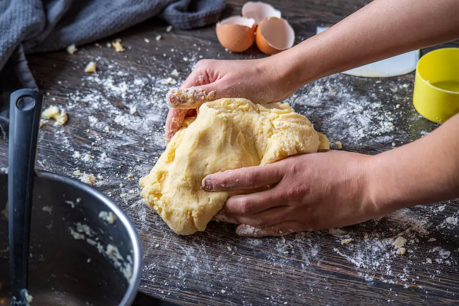 A person kneading dough on a lightly floured surface